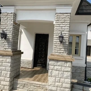 Workers installing concrete paving stones on a driveway